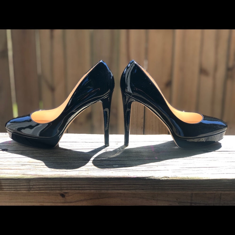 A pair of JIMMY CHOO patent leather black heels.